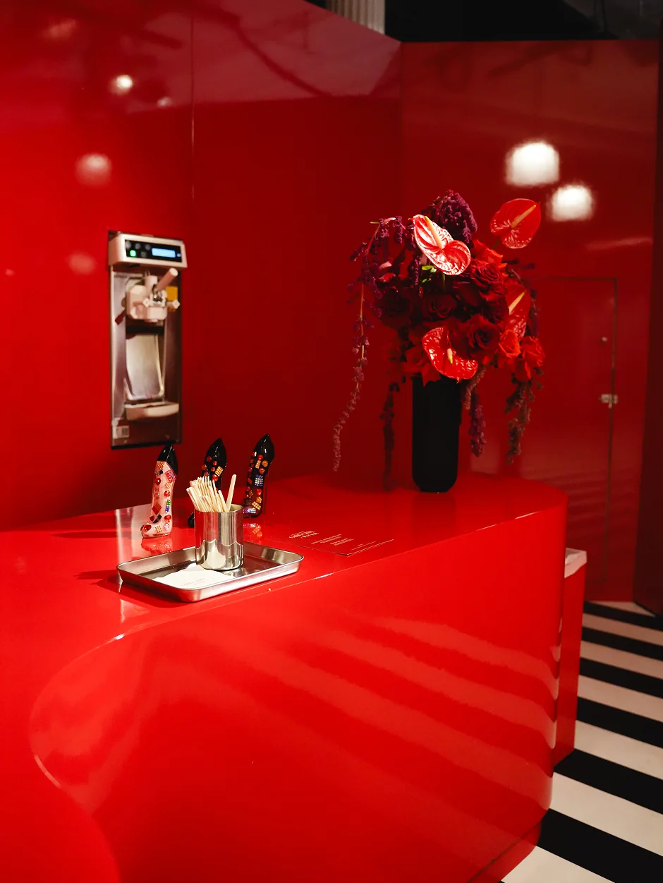 Red installation and floral arrangement inside Good Girl Lab